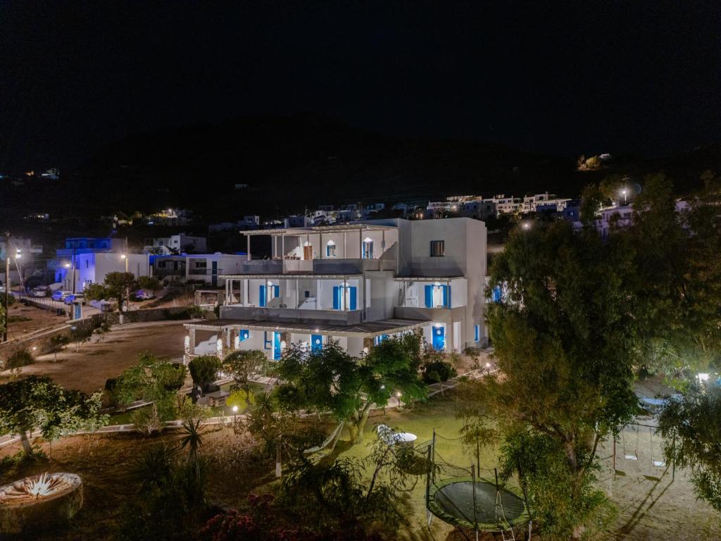 a large white building with blue doors at night at Dorkas Luxury Rooms&Apartments in Livadakia