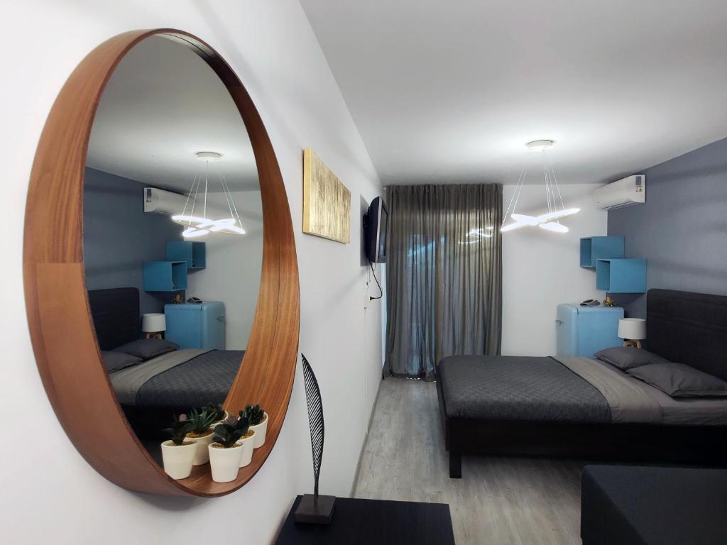 a living room with a mirror and a bed at ALFA BETA RESIDENCE in Saturn