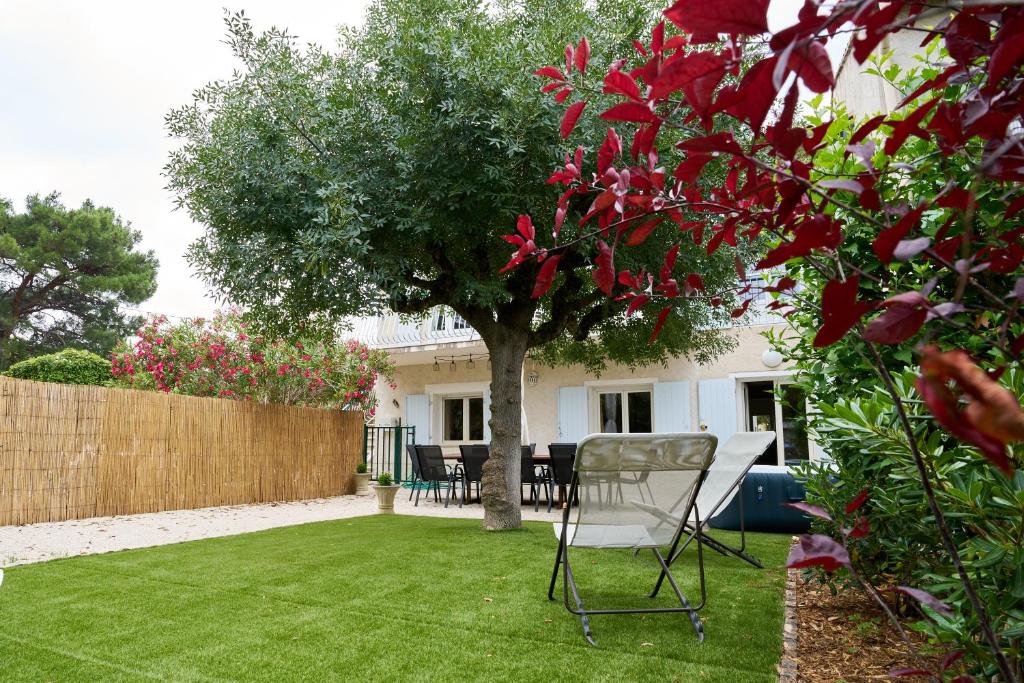 a chair sitting in the yard of a house at Maison familiale avec jacuzzi, quartier calme in Avignon