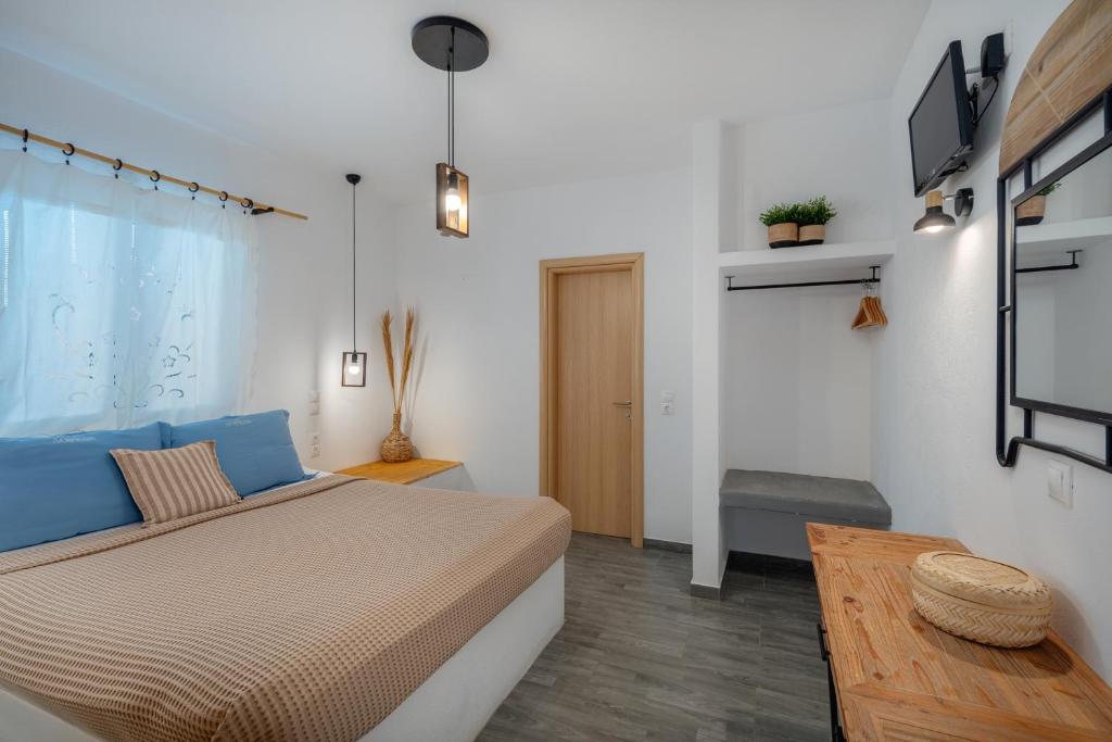 a bedroom with a large bed and a table at Dorkas Luxury Rooms&Apartments in Livadakia