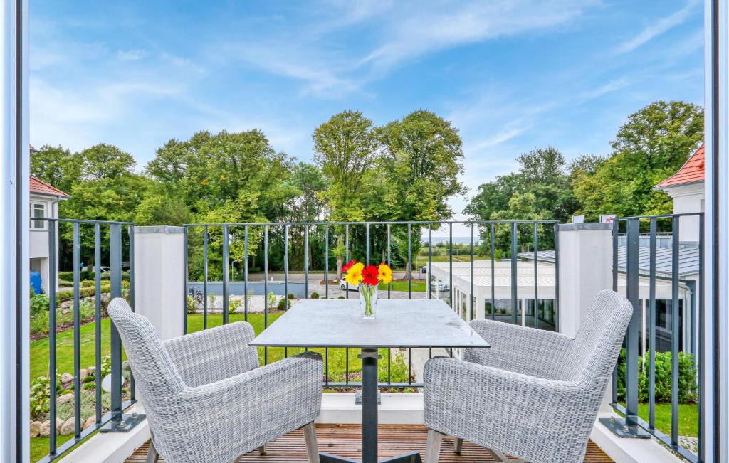eine Terrasse mit Stühlen und einem Tisch mit einer Blumenvase in der Unterkunft Baltischer Hof Apartment 42 in Boltenhagen