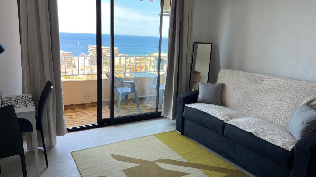 un salon avec un canapé et une vue sur l'océan dans l'établissement Le plein soleil, à Ajaccio