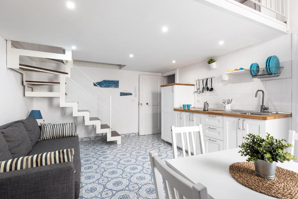 een keuken en woonkamer met een bank en een tafel bij La cianciola in Gaeta