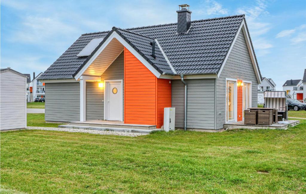 an orange and gray house with a yard at Mein Herzensort in Olpenitz
