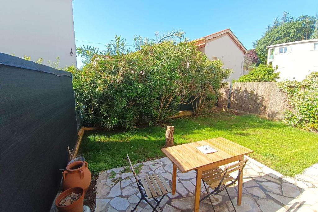 une petite arrière-cour avec une table et des chaises en bois dans l'établissement Refurbished apartment with terrace and garden, à Nice