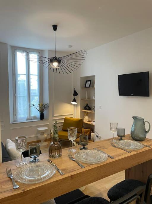 - une table en bois avec des assiettes dans le salon dans l'établissement Studio centre au calme avec parking privé, à Cannes