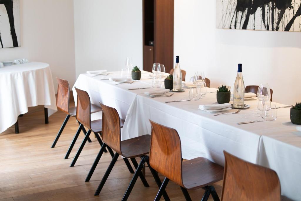 a long white table with chairs and wine bottles at Grand Hôtel Champs-Elysées in Paris