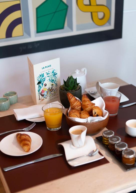 a table with croissants and a bowl of croissants and drinks at Grand Hôtel Champs-Elysées in Paris