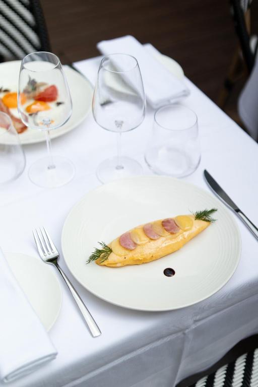 a plate of food on a table with wine glasses at Grand Hôtel Champs-Elysées in Paris
