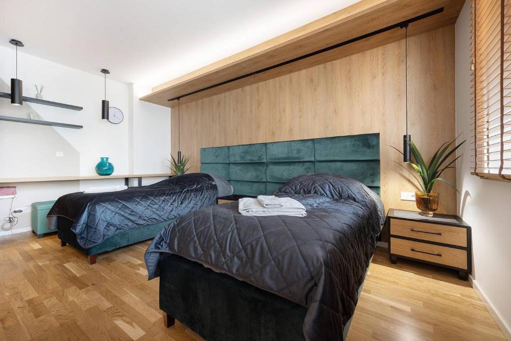 zwei Betten befinden sich in einem Zimmer mit Holzboden in der Unterkunft M&M Living in Hannover City in Hannover