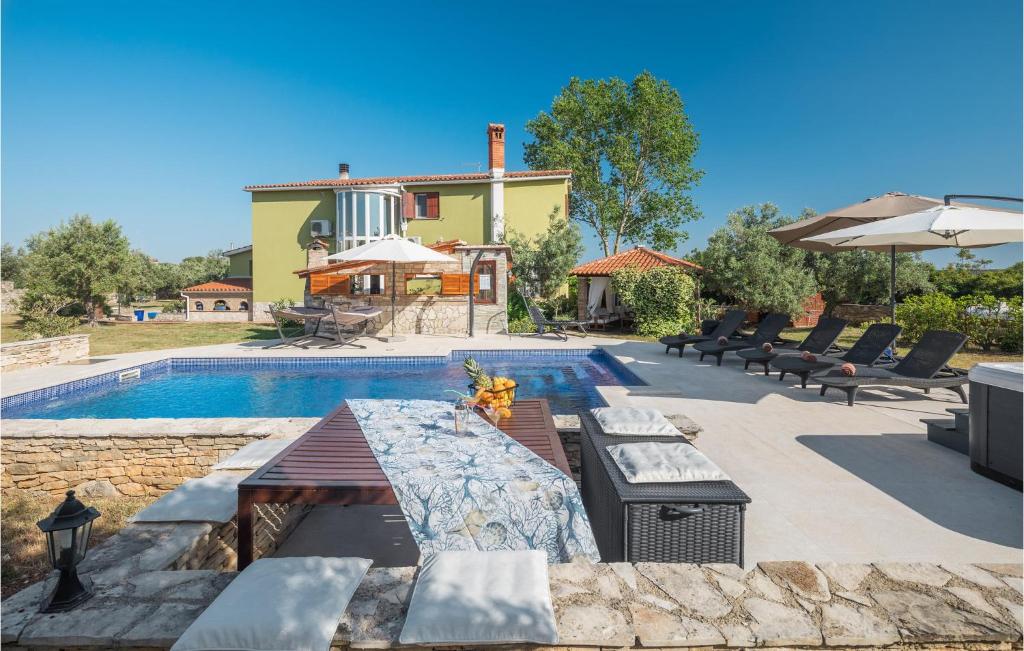 basen z krzesłami oraz dom i budynek w obiekcie Nice Home In Galizana w mieście Galižana