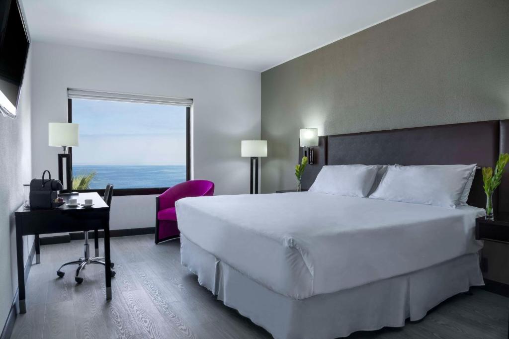Una cama o camas en una habitación de NH Iquique Costa