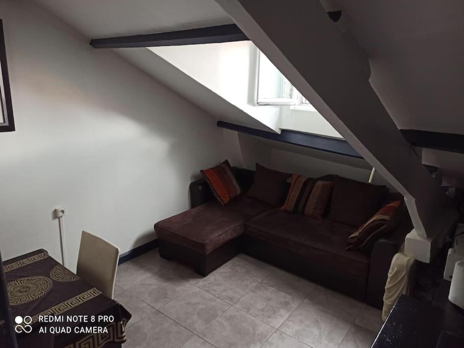 un salon avec un canapé et une fenêtre dans l'établissement F3 A 400 m du Stade de France JO, à Saint-Denis