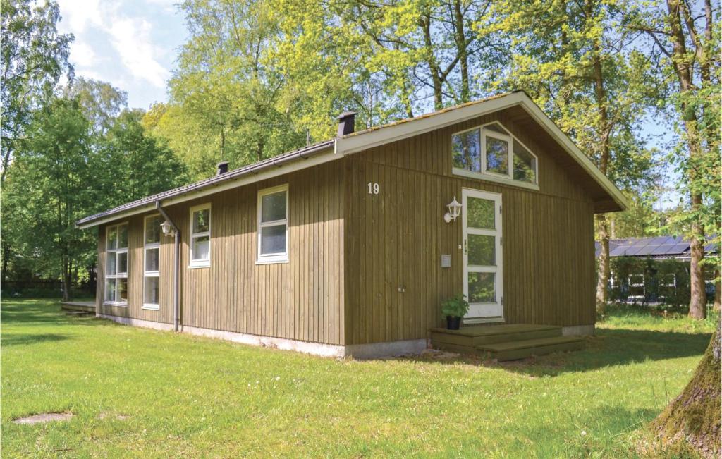 a small house in a yard with a grass field at Holiday Home Villesensvej Ii in Fjellerup