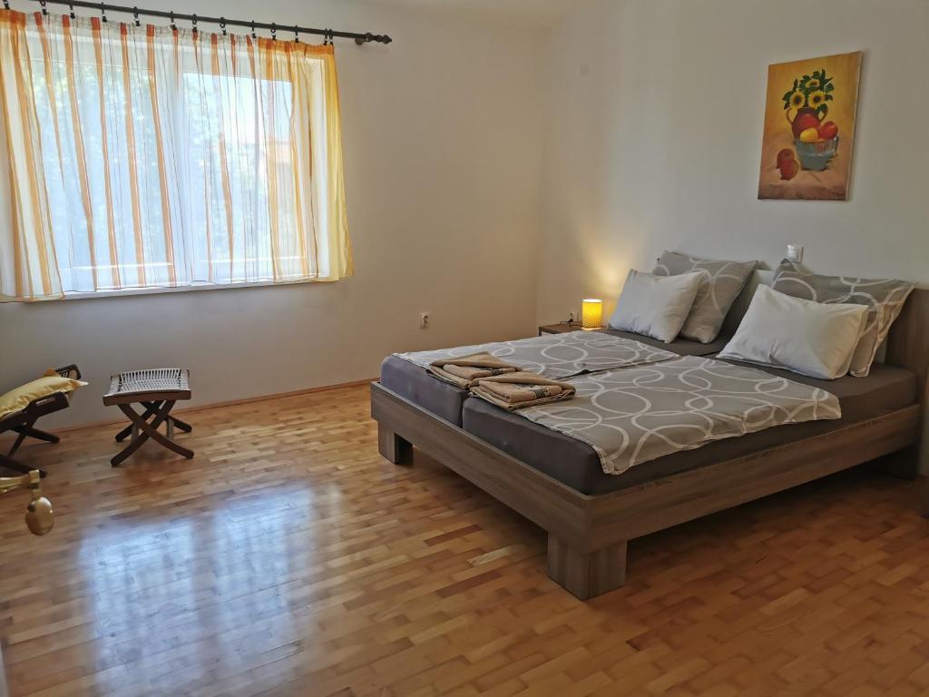 a bedroom with a large bed with a wooden floor at Apartment Kira - spacious apartment with sea view in Ližnjan