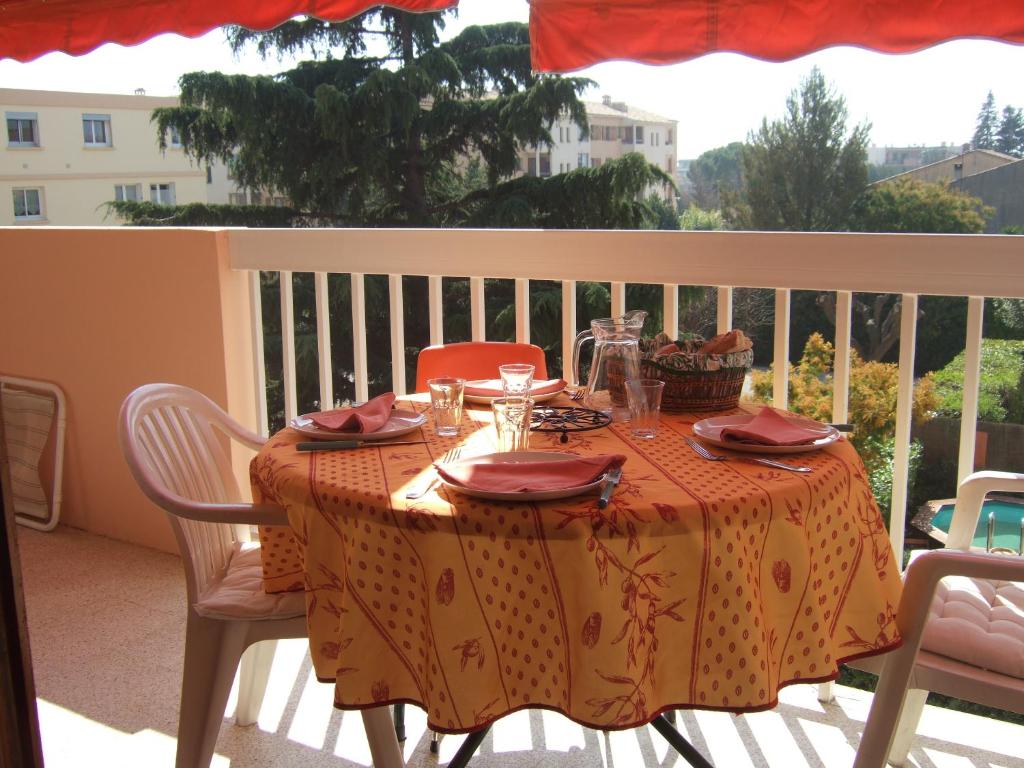 une table avec un chiffon de table sur un balcon dans l'établissement Ensoleillé, à Sanary-sur-Mer