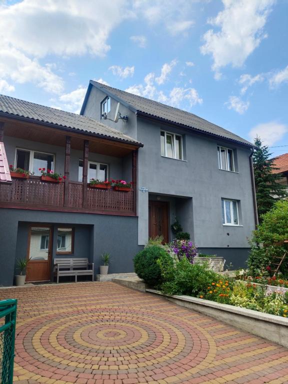 a gray house with a brick driveway in front of it at Dream House in Yaremche