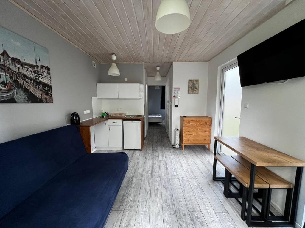 a living room with a blue couch and a kitchen at Sopot 34 przy plaży in Sopot