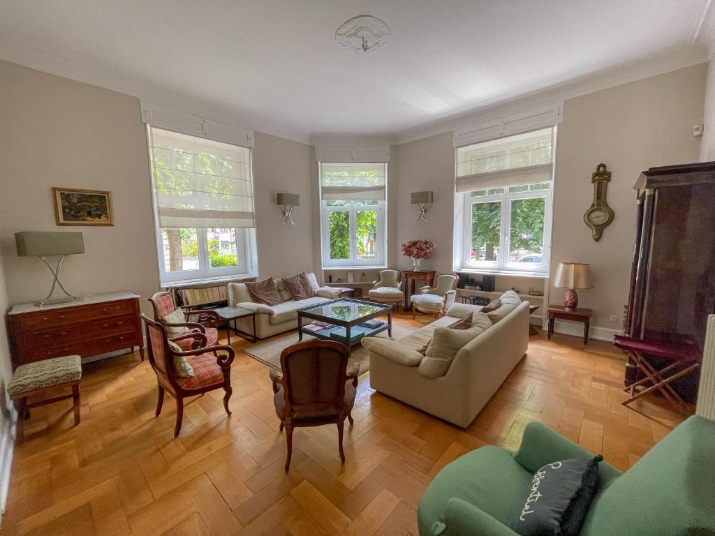 - un salon doté de meubles et de fenêtres dans l'établissement Appartement de standing 200m², à Strasbourg
