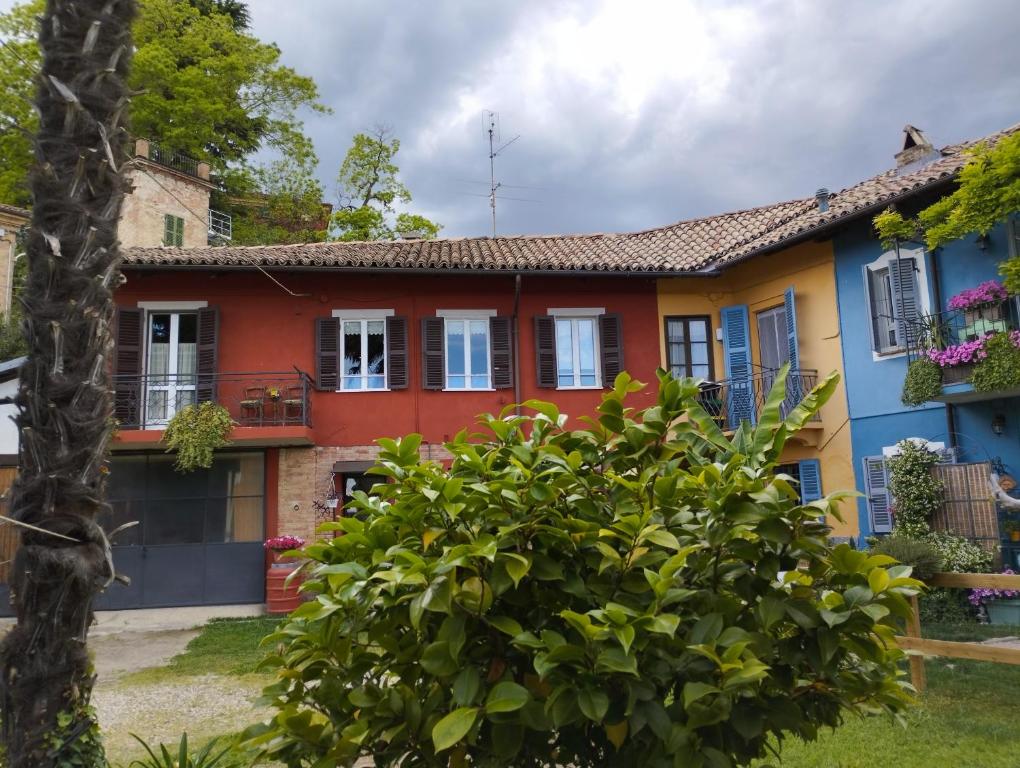 a colorful house with a tree in front of it at Ca' d'la nona casa con giardino in Agliano Terme
