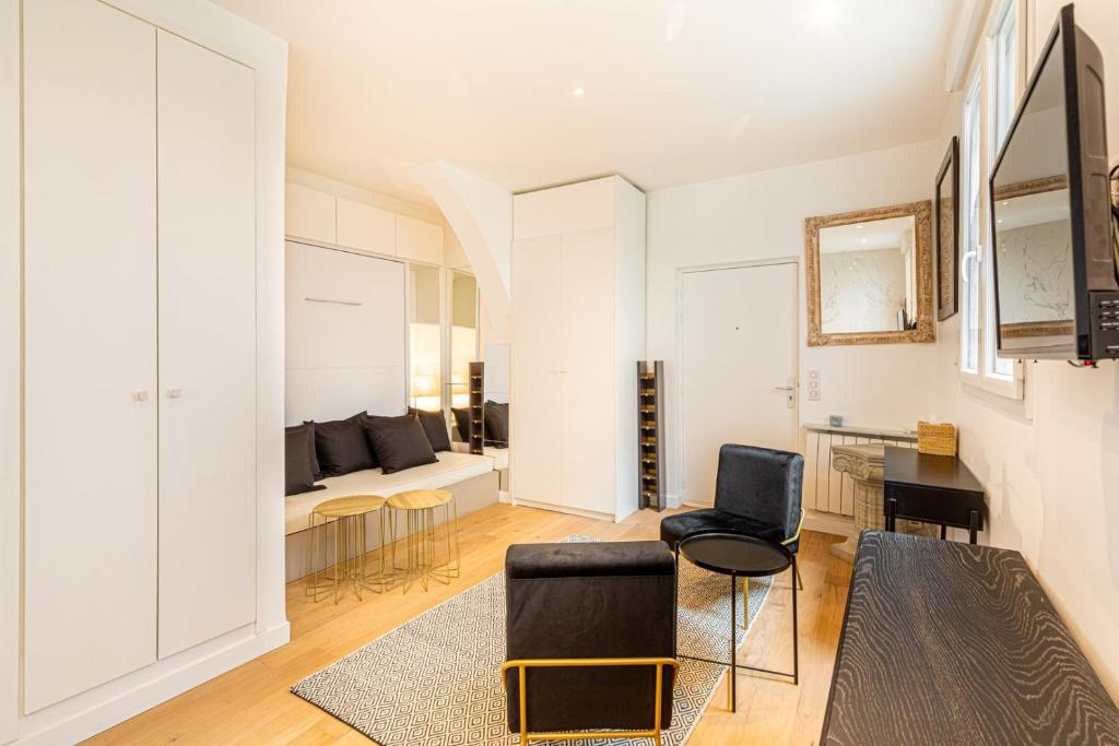 un salon avec deux chaises et un canapé dans l'établissement GuestReady - Élysée Palace Marble Haven, à Paris