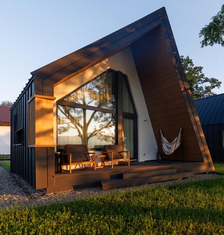a tiny house with a large window and a patio at Reconnect Glamping Stulpicani in Stulpicani