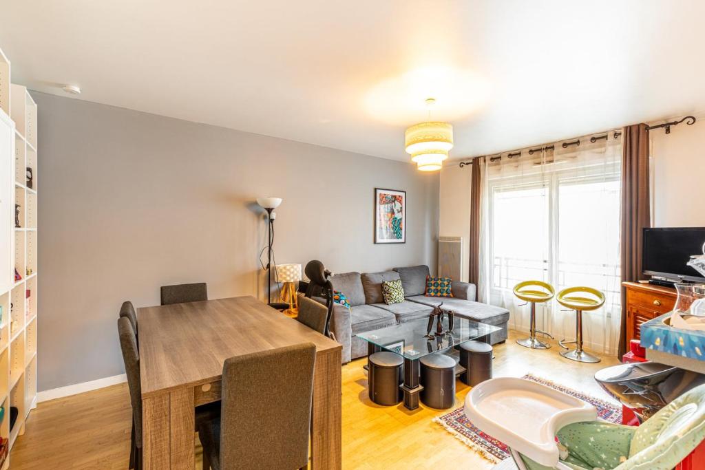 un salon avec une table et un canapé dans l'établissement GuestReady - Red Letters in Montrouge, à Montrouge