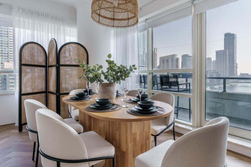 a dining room with a table and chairs and a large window at GuestReady - Bohemian Apt with Marina View in Dubai