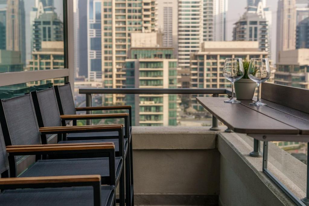 a balcony with tables and chairs and a view of a city at GuestReady - Bohemian Apt with Marina View in Dubai
