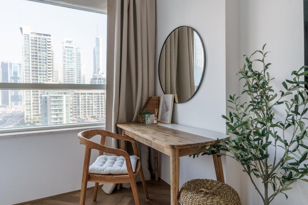 a desk in a room with a mirror and a window at GuestReady - Bohemian Apt with Marina View in Dubai