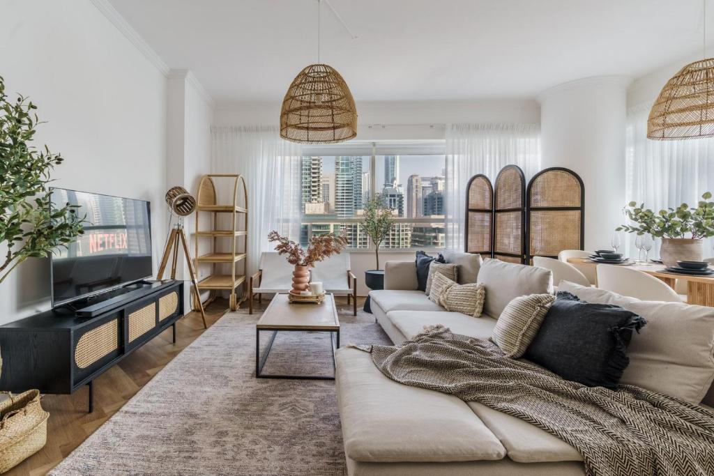 a living room with a couch and a tv at GuestReady - Bohemian Apt with Marina View in Dubai