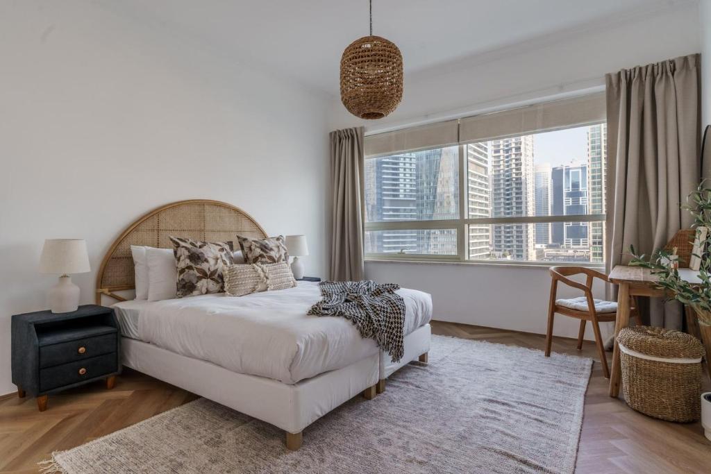 a bedroom with a bed and a large window at GuestReady - Bohemian Apt with Marina View in Dubai