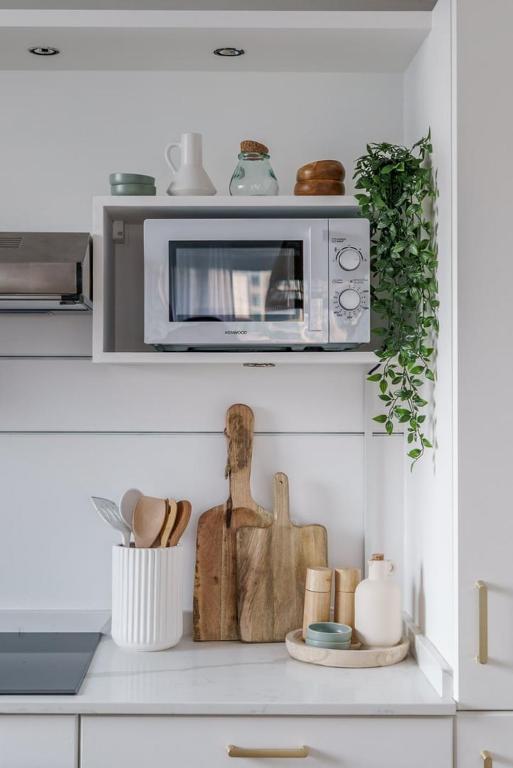 a kitchen with a microwave and a counter with some items at GuestReady - Bohemian Apt with Marina View in Dubai