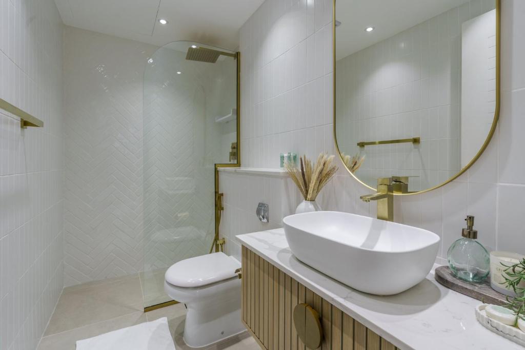 a bathroom with a sink and a toilet and a mirror at GuestReady - Bohemian Apt with Marina View in Dubai
