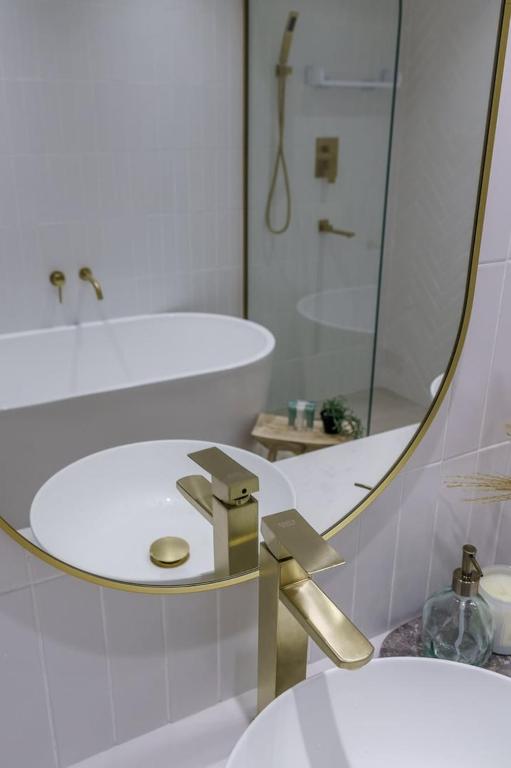 a bathroom with a gold sink and a mirror at GuestReady - Bohemian Apt with Marina View in Dubai