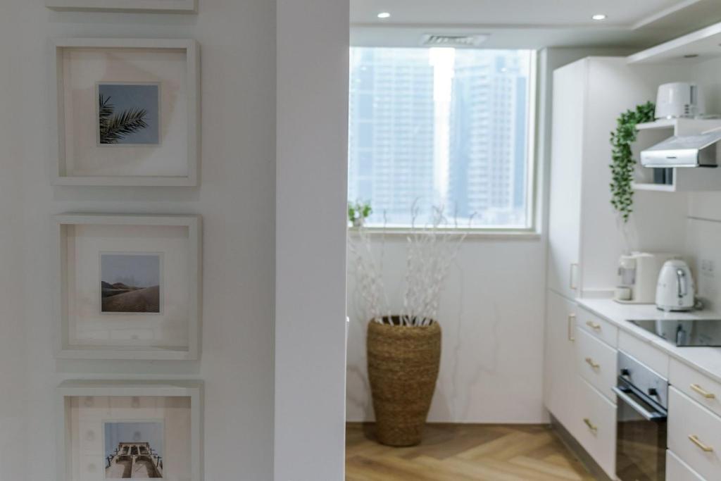 a kitchen with white walls and a fireplace at GuestReady - Bohemian Apt with Marina View in Dubai