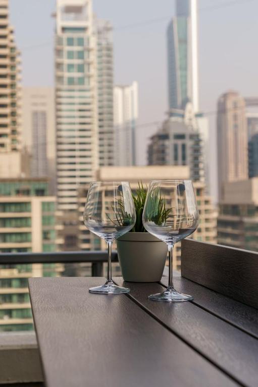 two wine glasses on a table with a view of a city at GuestReady - Bohemian Apt with Marina View in Dubai
