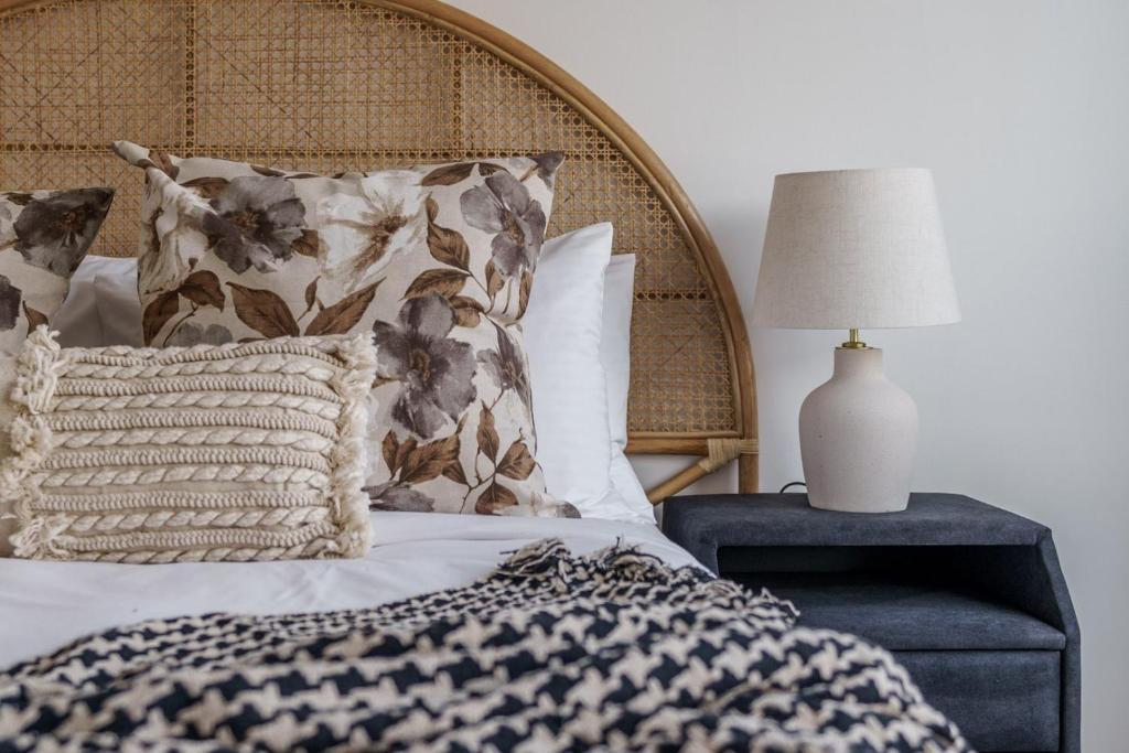 a bed with pillows and a table with a lamp at GuestReady - Bohemian Apt with Marina View in Dubai