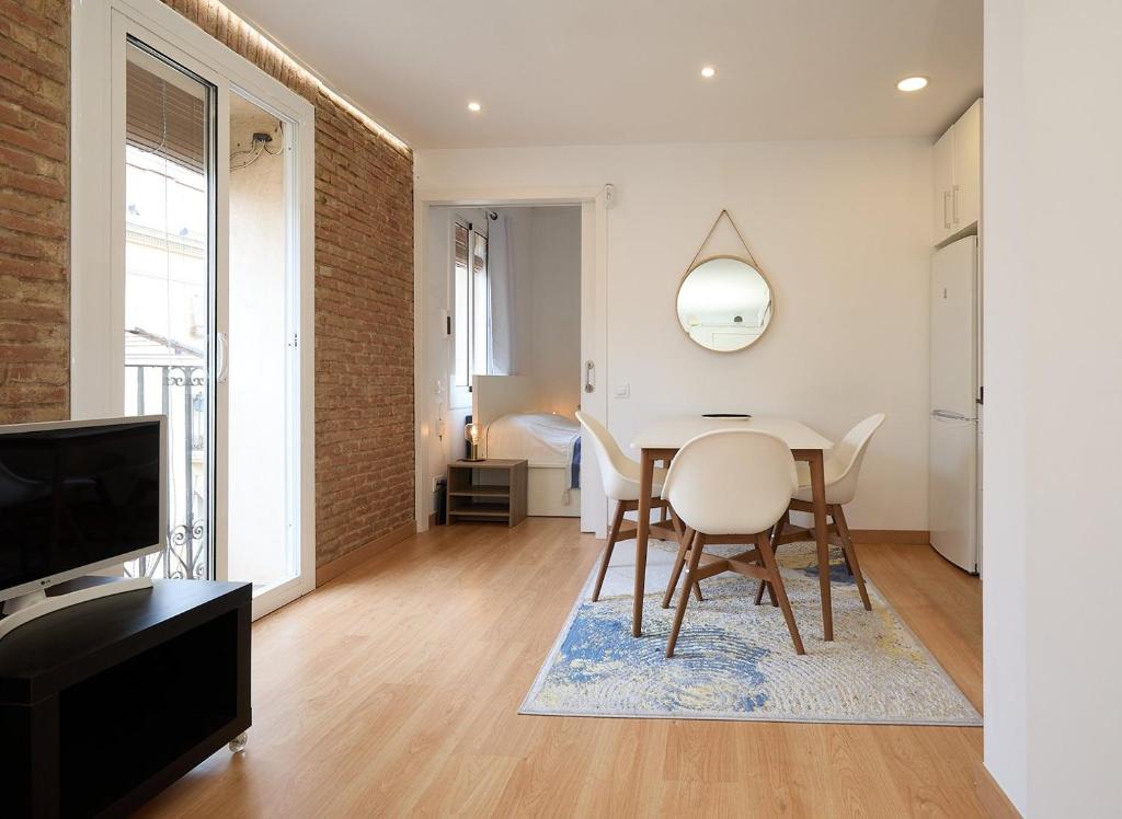 sala de estar con mesa, sillas y TV en GuestReady - Acogedor Apt en La Barceloneta, en Barcelona