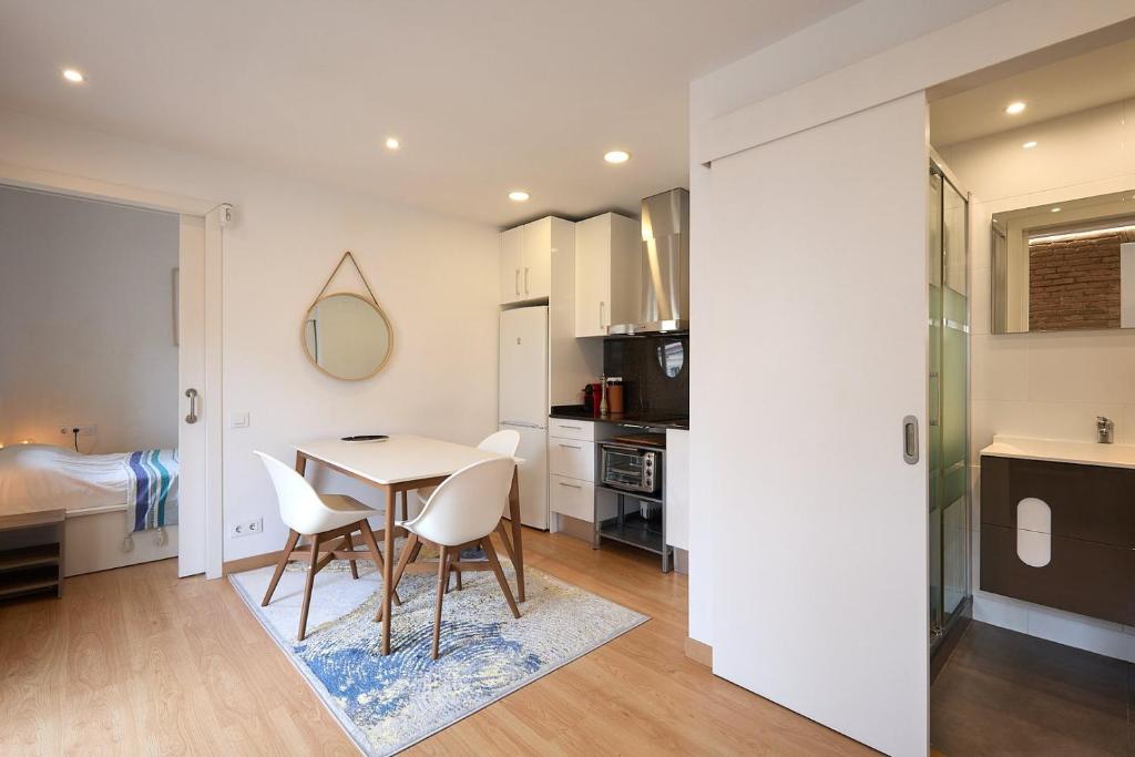 Una cocina y un comedor con mesa y sillas. en GuestReady - Acogedor Apt en La Barceloneta, en Barcelona