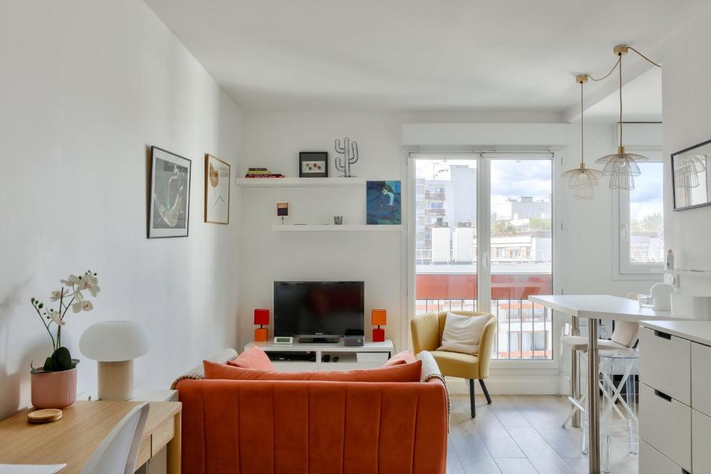 un salon avec un canapé orange et une table dans l'établissement Bel appart à 5 min à pied de la station de métro, à Paris