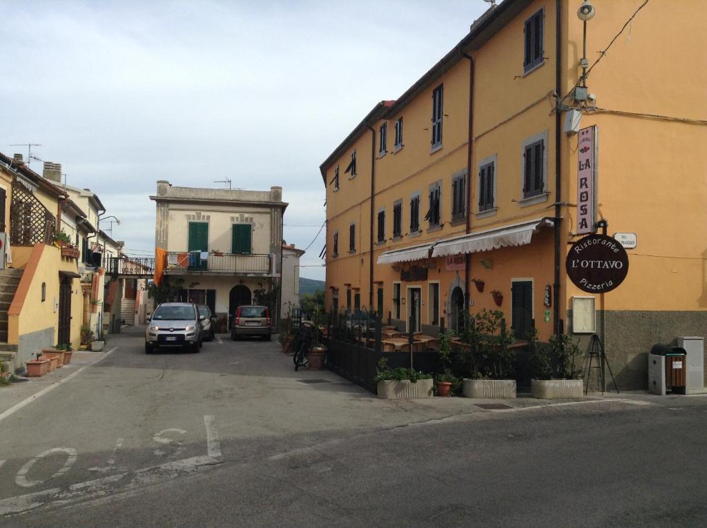 a street in a town with cars parked on the road at Hotel La Rosa in San Piero in Campo