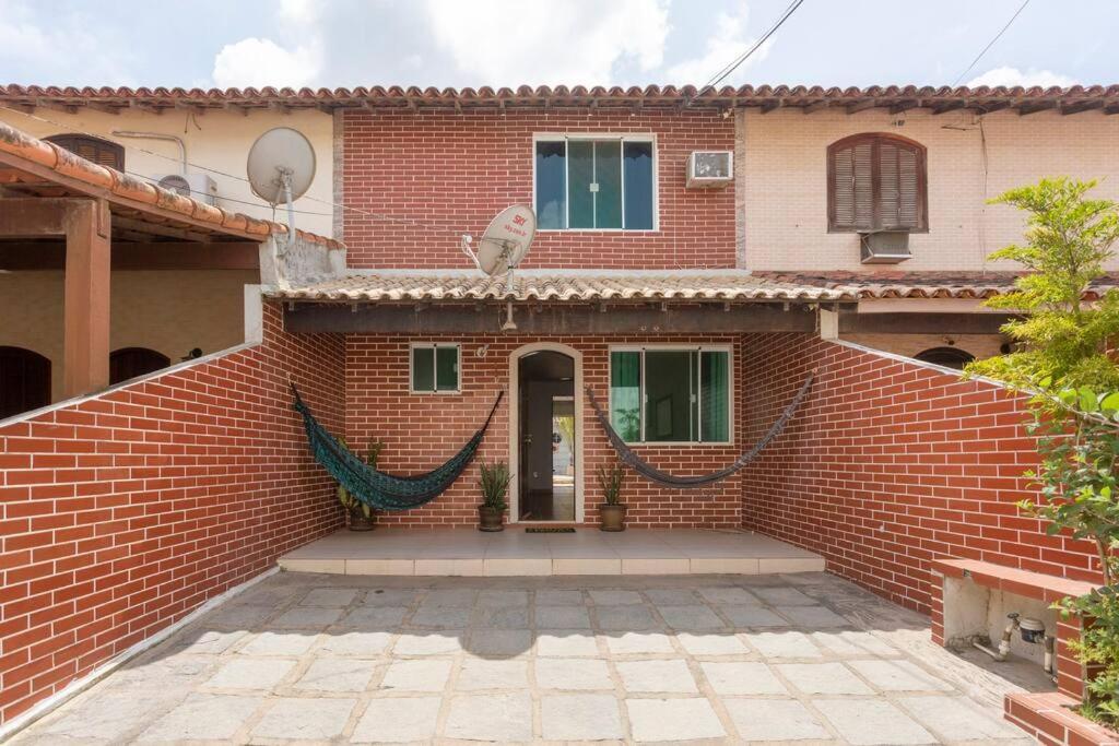 a brick house with a hammock in front of it at Casa Privativa com Piscina, Churrasqueira, Mesa de Sinuca in Iguaba Grande