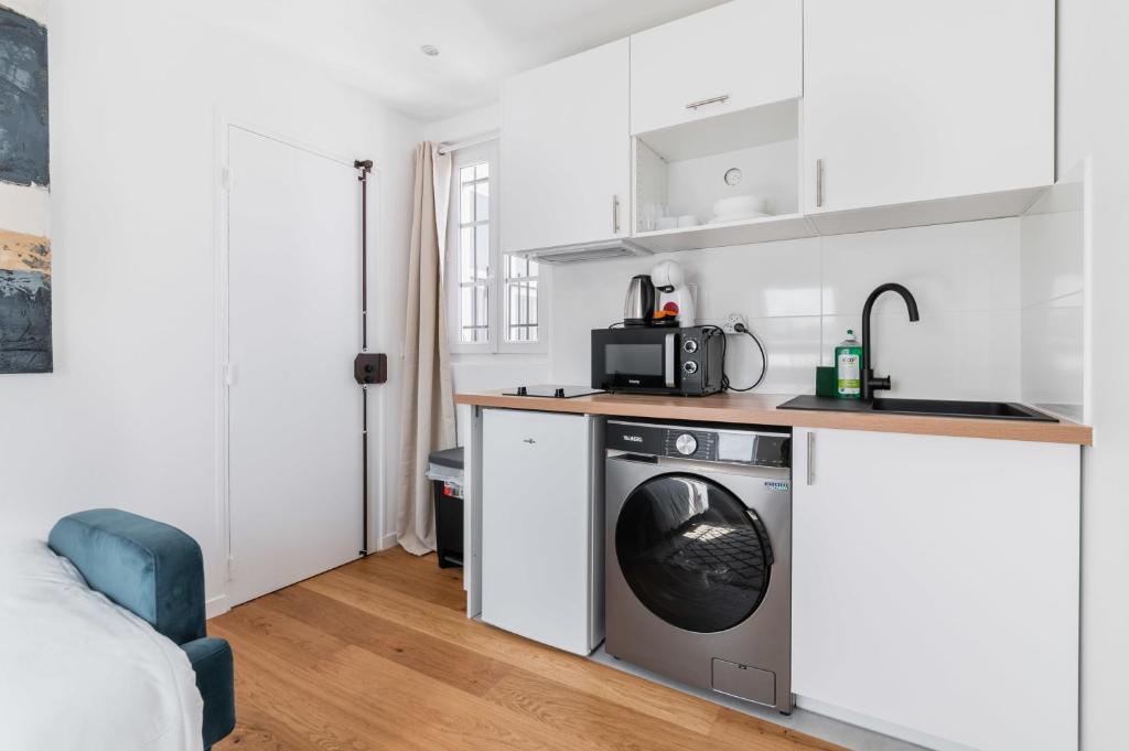 une cuisine avec une machine à laver dans une pièce dans l'établissement Studio refait a neuf dernier etage - Paris 19 - 2P - FLAT-GUEST - FLAT-GUEST, à Paris
