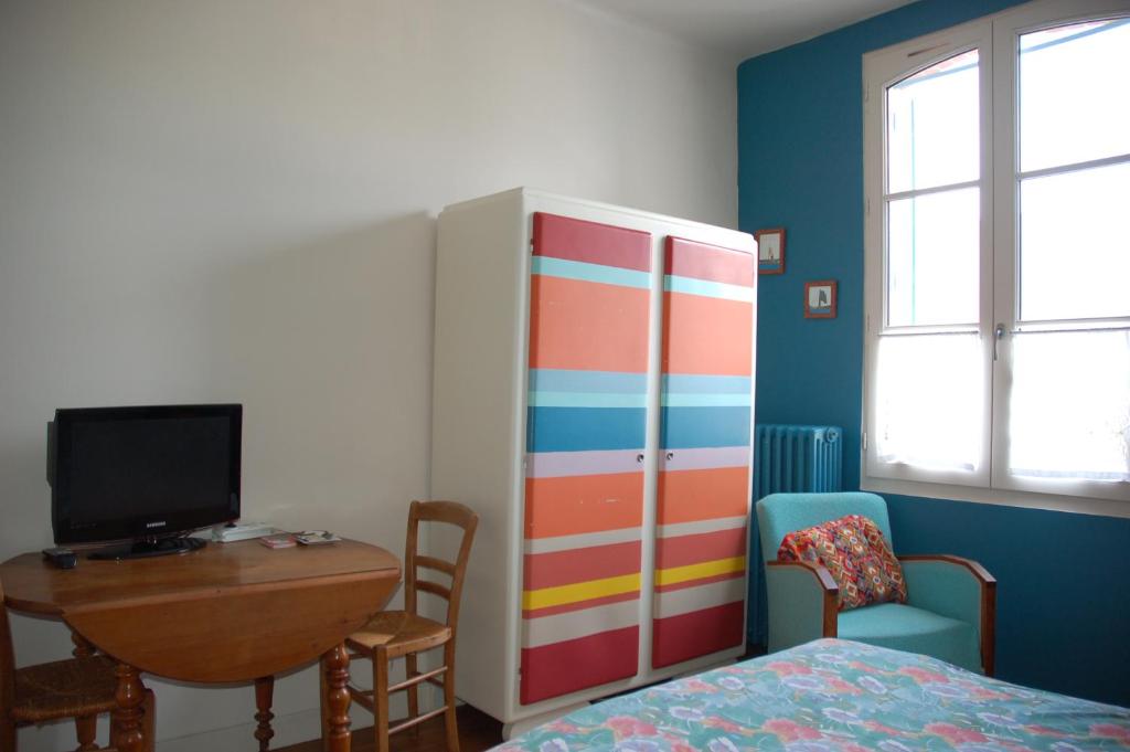 Un dormitorio con una cama, un escritorio y un armario. en Chambre indépendante avec salle de bains privée, en Rennes