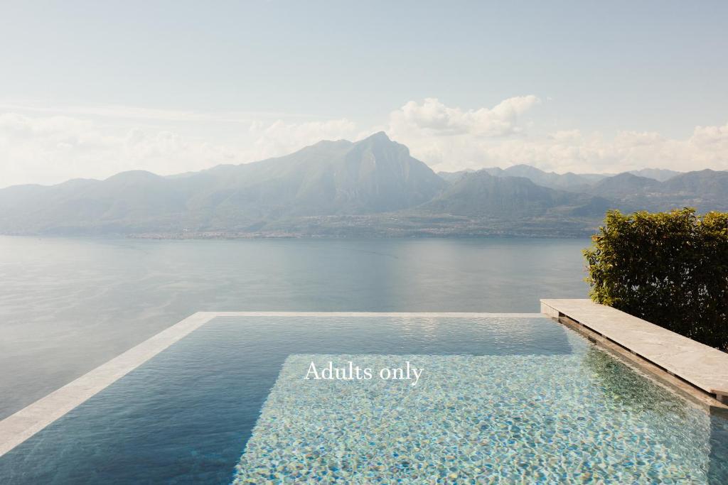 a swimming pool with a view of a body of water at Cape of Senses in Torri del Benaco