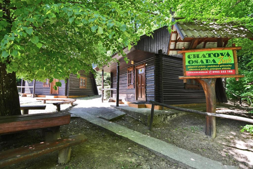 a wooden cabin with a sign in front of it at Chatová Osada Zrub in Vinné