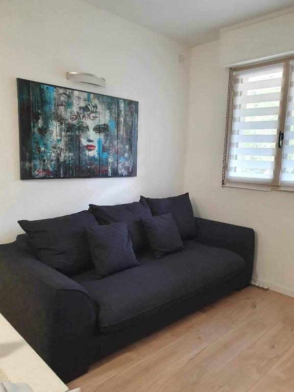 un canapé noir dans une pièce avec une fenêtre dans l'établissement le Nid Enchanté, à Cavalaire-sur-Mer