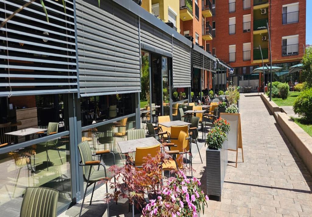 a patio with tables and chairs in front of a building at Superb 1 bedroom in the best zone of the city. in Ferizaj