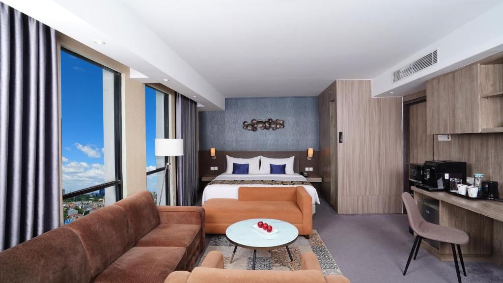 a hotel room with a bed and a couch at ASTON Inn Pandanaran in Semarang